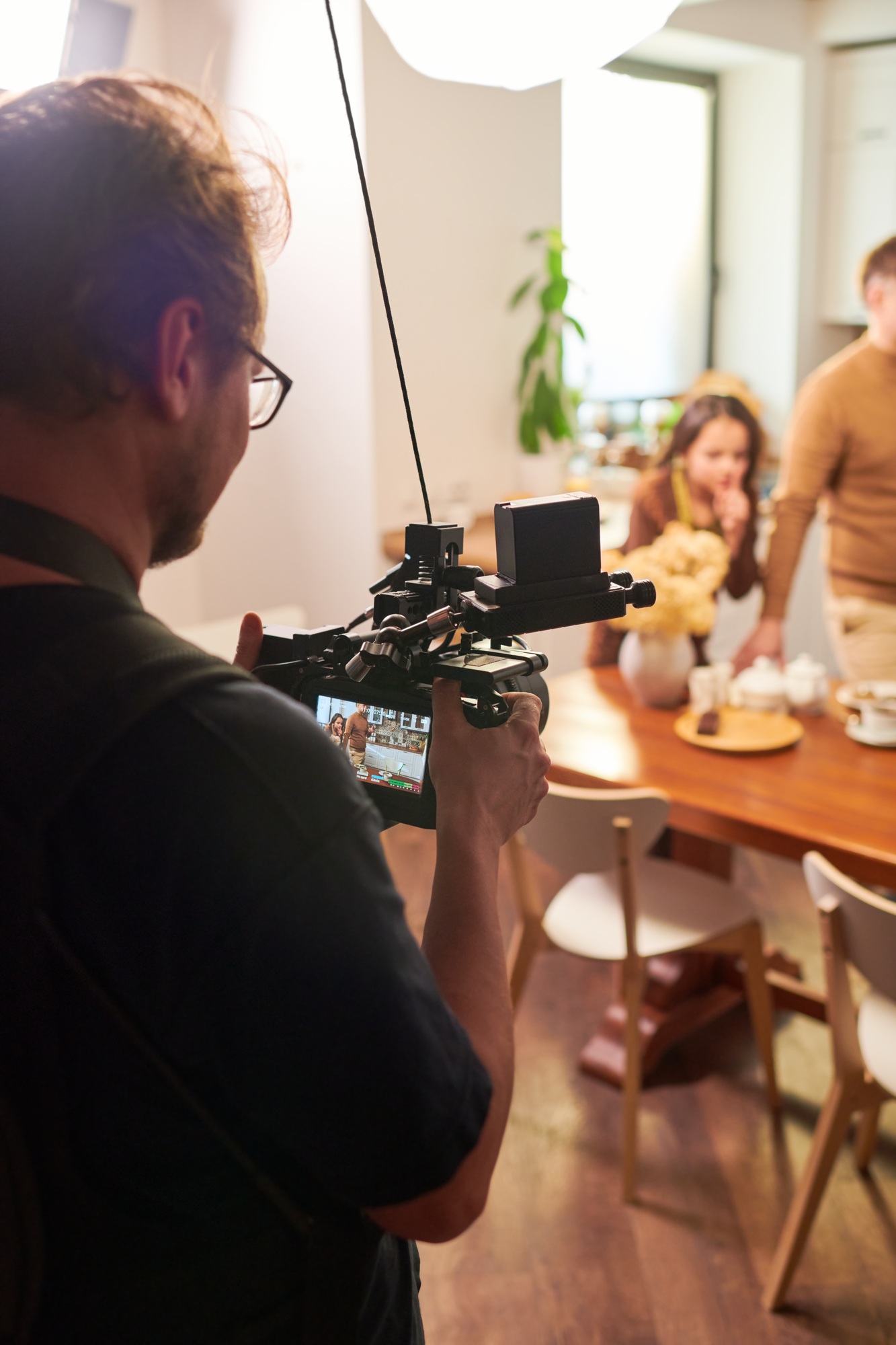 Young operator or videographer with videocamera shooting cooking masterclass Young operator or videographer with videocamera shooting cooking masterclass