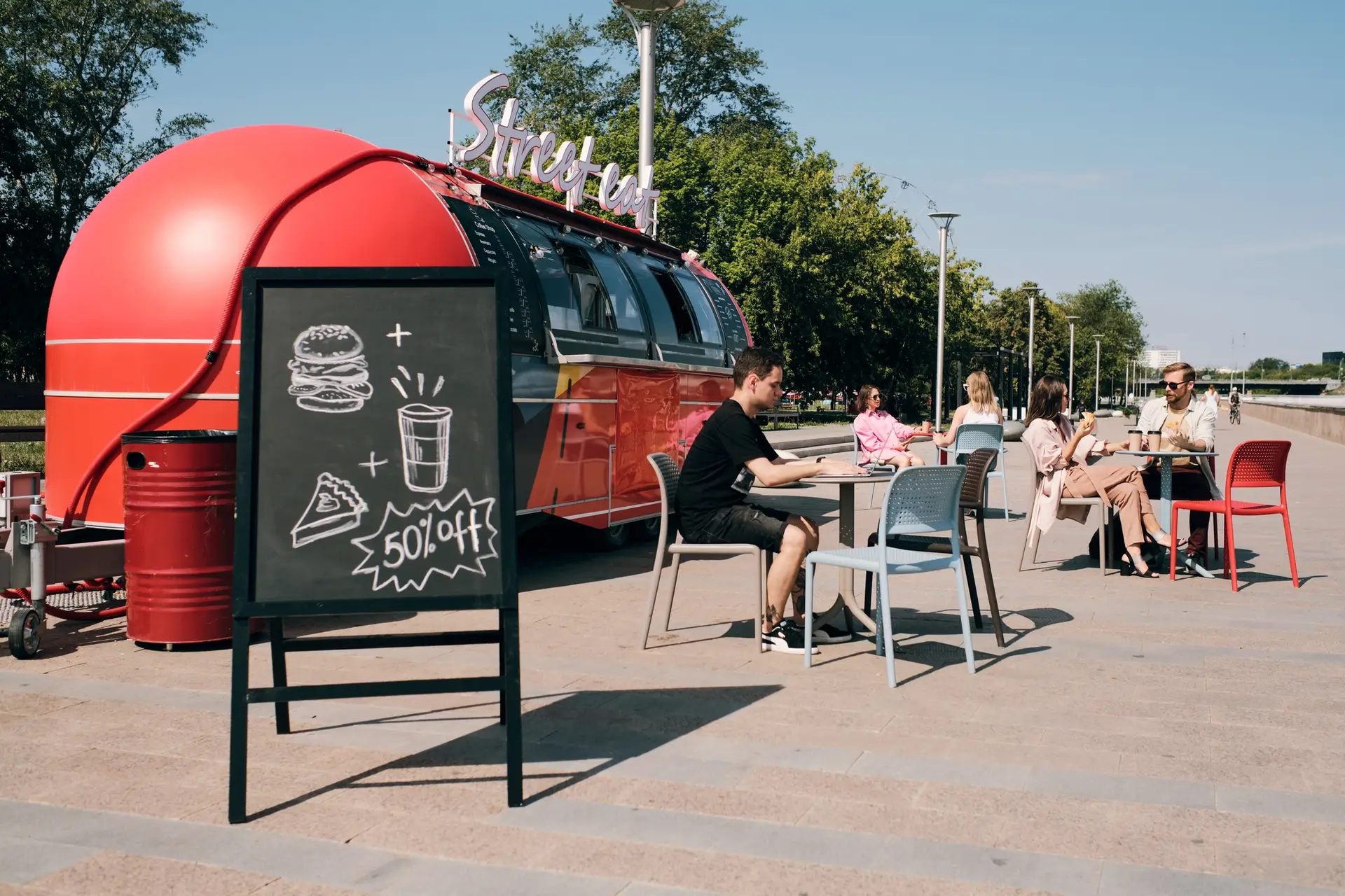 Blackboard with discount announcement against outdoor cafe